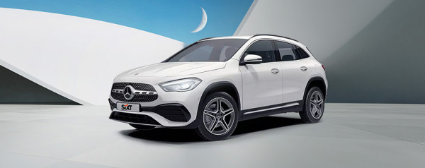 Biały Mercedes-Benz SUV na futurystycznym tle z geometrycznymi kształtami i księżycem w górnym rogu.