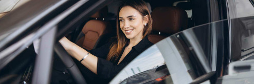 Kobieta siedząca za kierownicą nowoczesnego samochodu – wynajem auta do pracy i na wakacje z SIXT DriveSmart