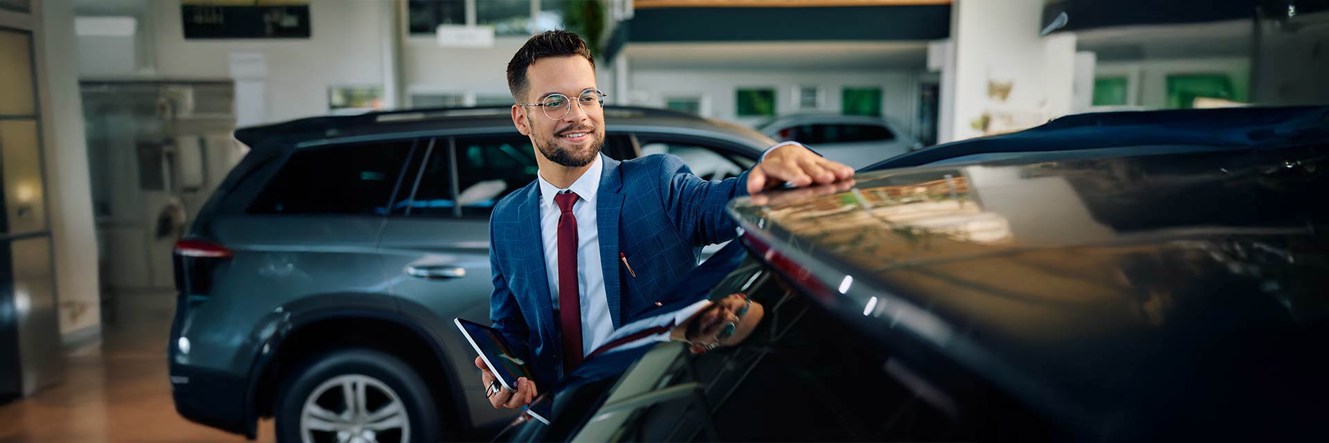 Doradca flotowy w salonie samochodowym ogląda auto – symbol elastycznego leasingu i wynajmu dla firm.