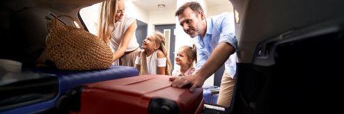 Rodzina pakująca bagaż do wynajętego auta przed wakacyjną podróżą