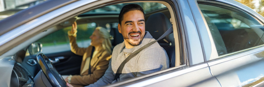 Kierowca w samochodzie z uśmiechem – nowoczesny wynajem długoterminowy w SIXT DriveSmart