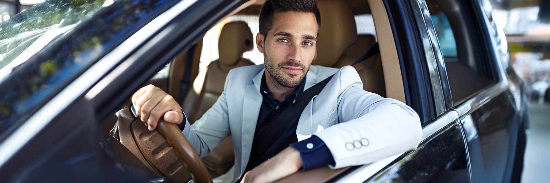 Mężczyzna siedzący w nowoczesnym samochodzie – symbol mobilności i elastyczności wynajmu długoterminowego w SIXT DriveSmart