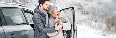 Para przy nowoczesnym samochodzie zimą – wynajem długoterminowy SIXT DriveSmart.