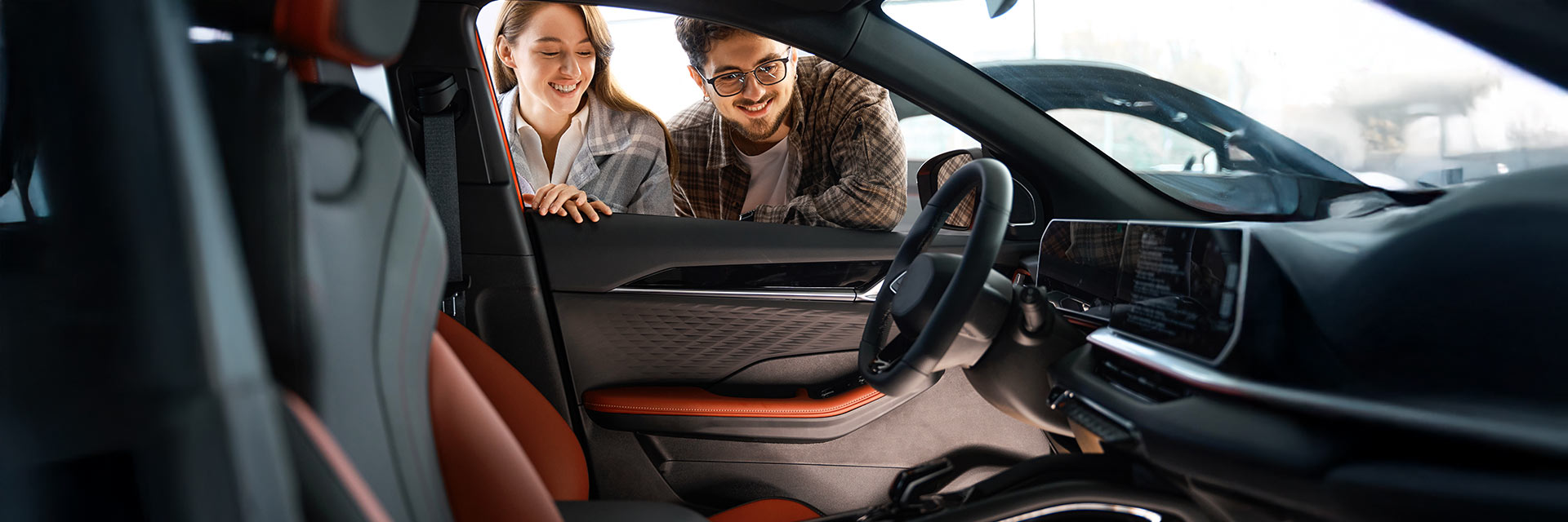 Para oglądająca wnętrze nowoczesnego samochodu – wynajem długoterminowy SIXT DriveSmart.