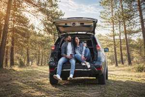 Para siedzi w bagażniku samochodu podczas majówkowego wyjazdu – wynajem auta na majówkę SIXT DriveSmart