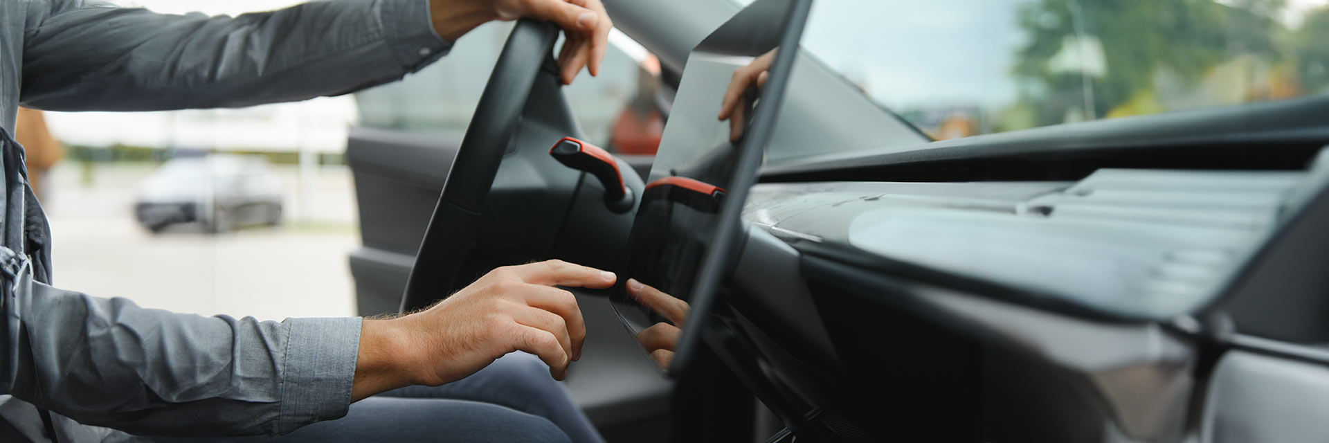 Kierowca korzystający z nowoczesnego systemu multimedialnego w samochodzie dostępnego w ofercie SIXT DriveSmart.