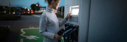 Kobieta korzystająca z publicznej stacji ładowania samochodów elektrycznych